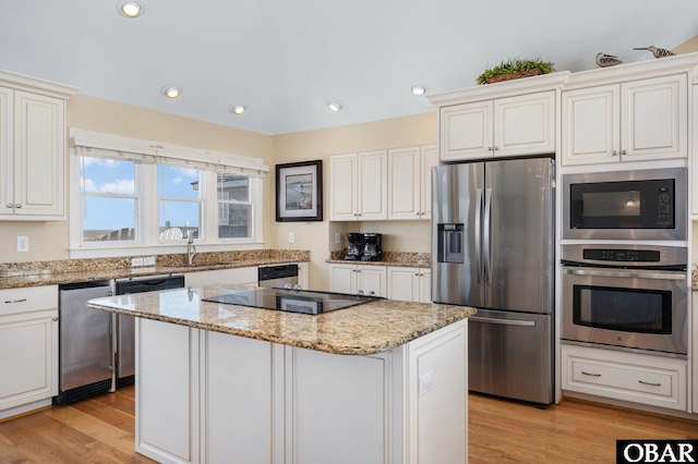 5001 S Virginia Dare Trl Lot 25, Nags Head, NC 27959 - kitchen with appliances with stainless steel finishes, a kitchen island, light stone counters, light wood finished floors, and recessed lighting