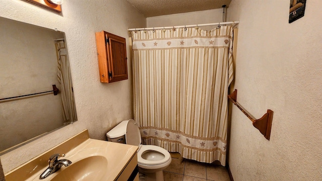 bathroom with curtained shower, a textured wall, toilet, vanity, and tile patterned floors