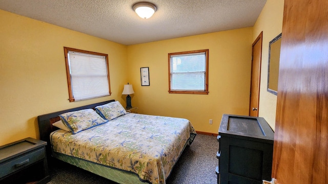 carpeted bedroom with a textured ceiling and baseboards