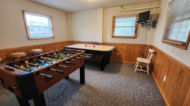 rec room featuring dark carpet, wainscoting, and wooden walls