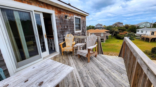 wooden terrace featuring a lawn