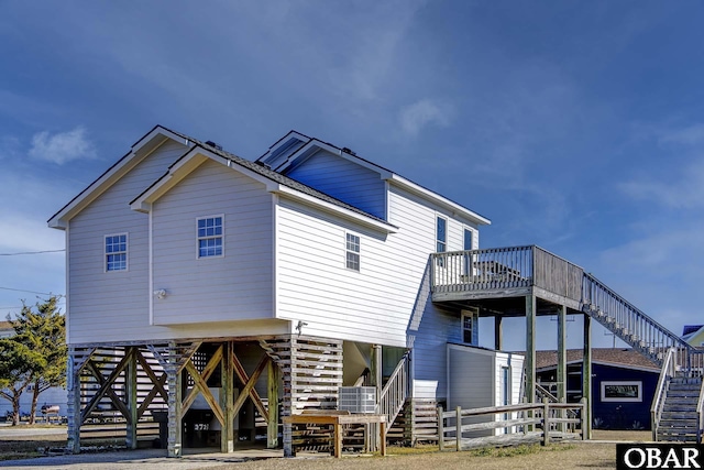 back of property featuring a carport, stairway, and a wooden deck