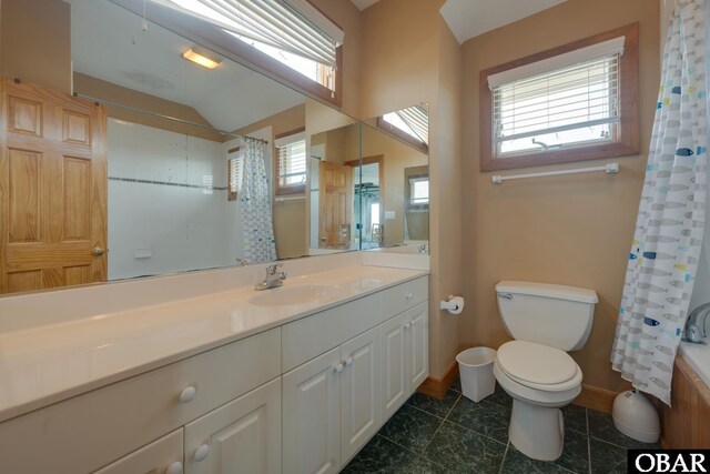 bathroom featuring lofted ceiling, toilet, vanity, baseboards, and tile patterned floors