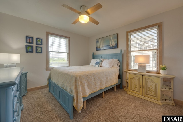 bedroom featuring light colored carpet, ceiling fan, and baseboards