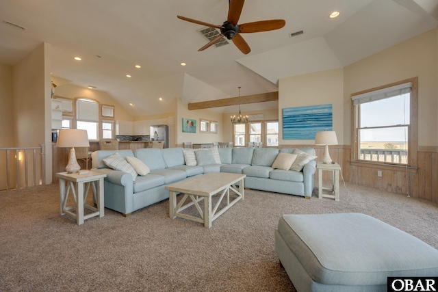 living area featuring a wainscoted wall, a wealth of natural light, vaulted ceiling, and visible vents