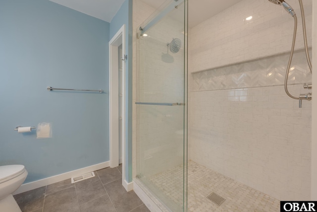 full bathroom featuring a stall shower, visible vents, baseboards, toilet, and tile patterned floors