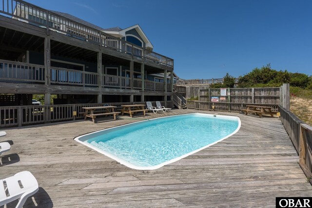 view of swimming pool featuring a fenced in pool and a deck