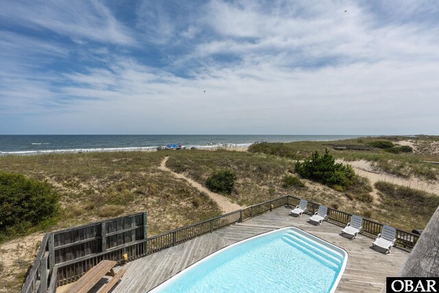 view of pool with a fenced in pool and a deck with water view