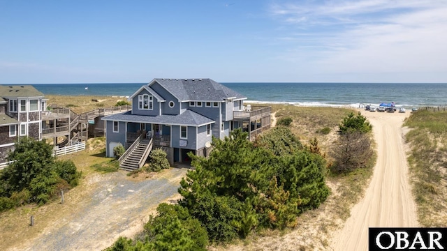 birds eye view of property featuring a water view and a beach view