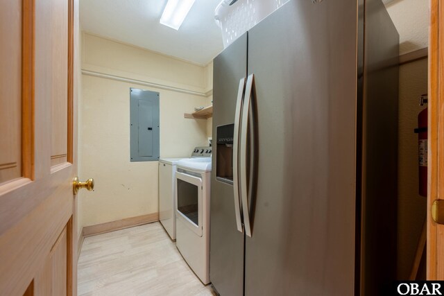 clothes washing area featuring laundry area, electric panel, baseboards, independent washer and dryer, and light wood-style floors