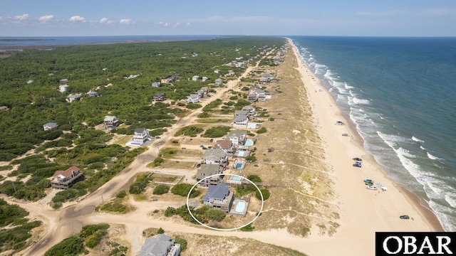 bird's eye view with a water view and a beach view