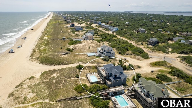 drone / aerial view featuring a beach view and a water view