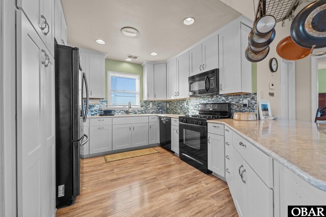1620 Sandpiper Rd Lot 2, Corolla, NC 27927 - kitchen with light wood finished floors, recessed lighting, decorative backsplash, white cabinetry, and black appliances