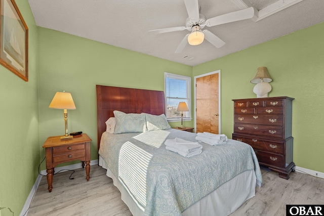 bedroom featuring baseboards, a ceiling fan, and light wood-style floors