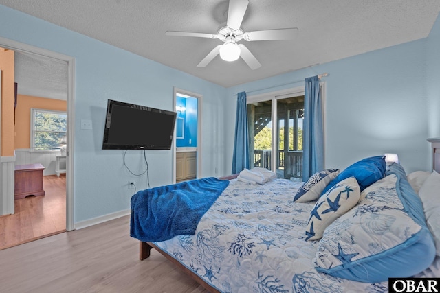 bedroom with access to exterior, multiple windows, a textured ceiling, and light wood-style floors