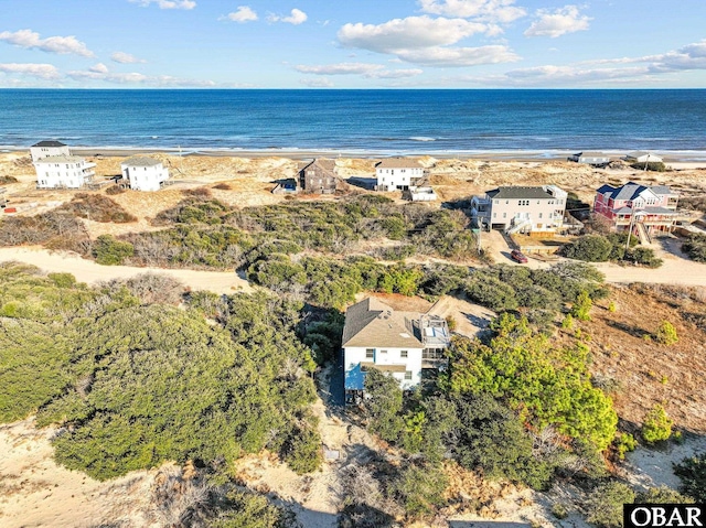 birds eye view of property featuring a water view and a beach view