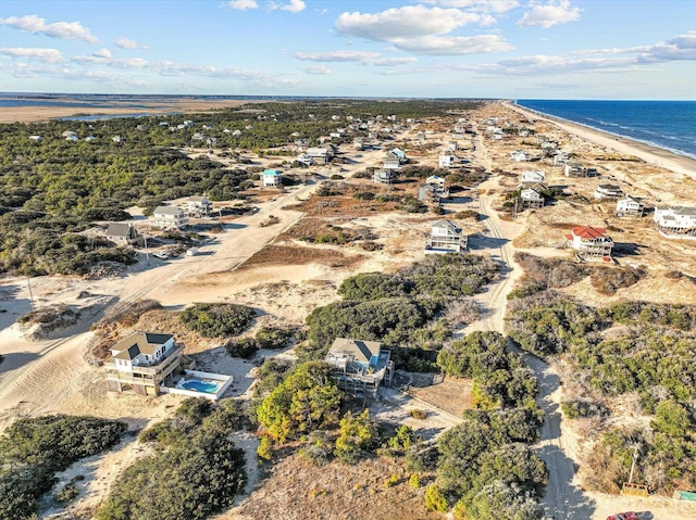 birds eye view of property with a water view and a view of the beach