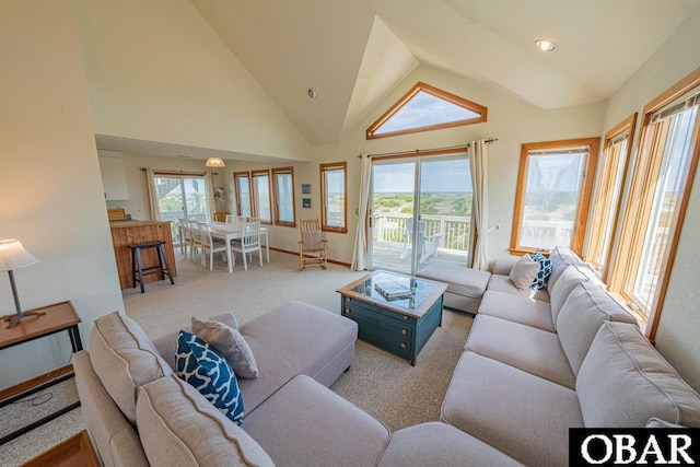 living room with carpet, baseboards, a wealth of natural light, and high vaulted ceiling