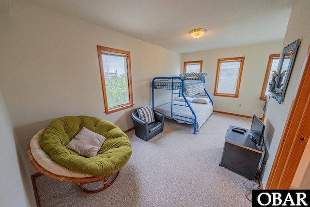 carpeted bedroom featuring baseboards and multiple windows