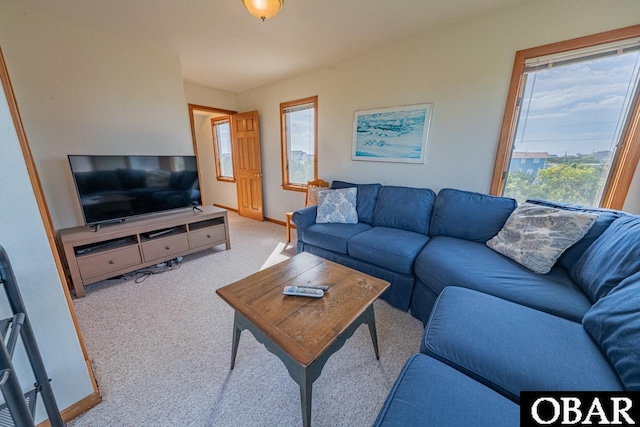 carpeted living room with a healthy amount of sunlight and baseboards