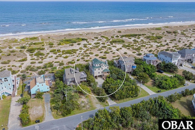 drone / aerial view featuring a beach view and a water view