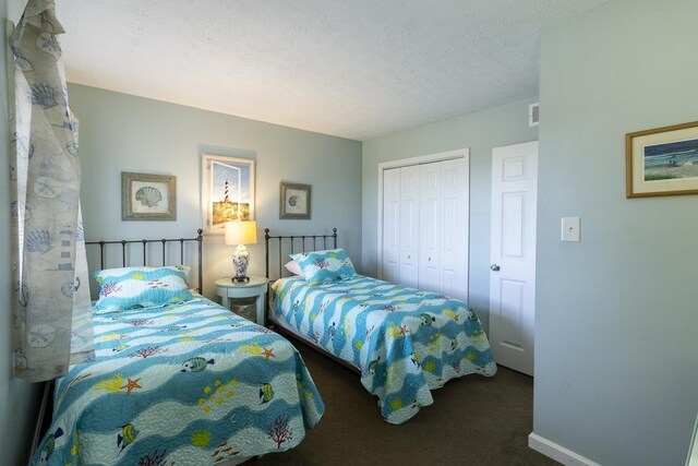 1541 N Virginia Dare Trl Lot 1-5, Kill Devil Hills, NC 27948 - bedroom featuring a closet, dark carpet, a textured ceiling, and baseboards