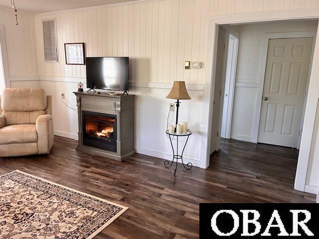 690 Irvin Garrish Hwy Lot # 2A, Ocracoke, NC 27960 - living area with dark wood-style flooring, a glass covered fireplace, baseboards, and wooden walls
