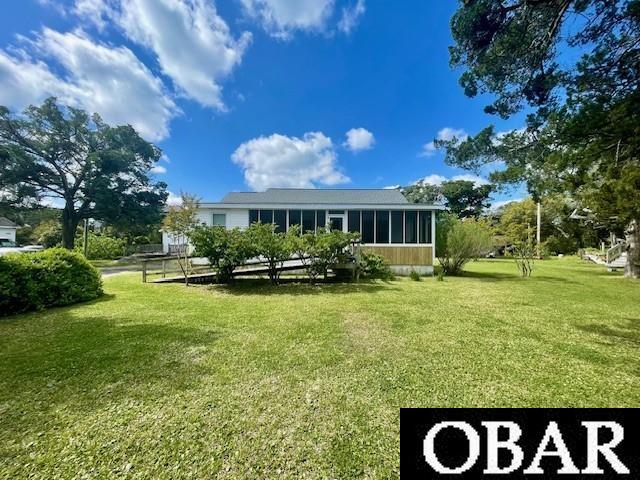 690 Irvin Garrish Hwy Lot # 2A, Ocracoke, NC 27960 - back of house with a sunroom and a lawn