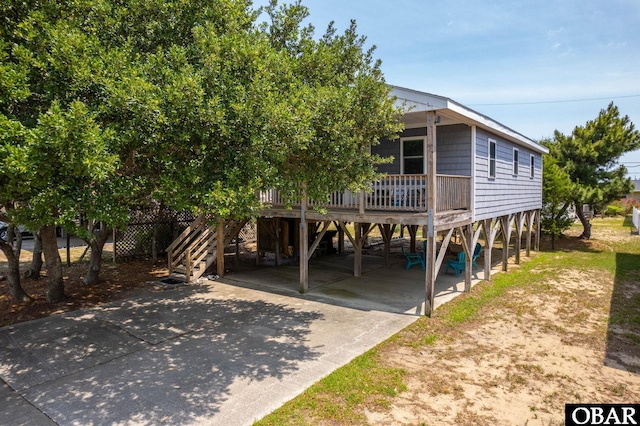 111 Carlow Ave Lot 18, Kill Devil Hills, NC 27948 - coastal home with stairway, a carport, concrete driveway, and covered porch