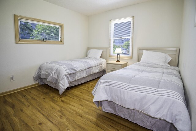 bedroom with dark wood-style flooring and baseboards