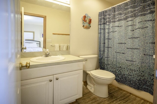 bathroom with a shower with shower curtain, toilet, ensuite bath, wood finished floors, and vanity