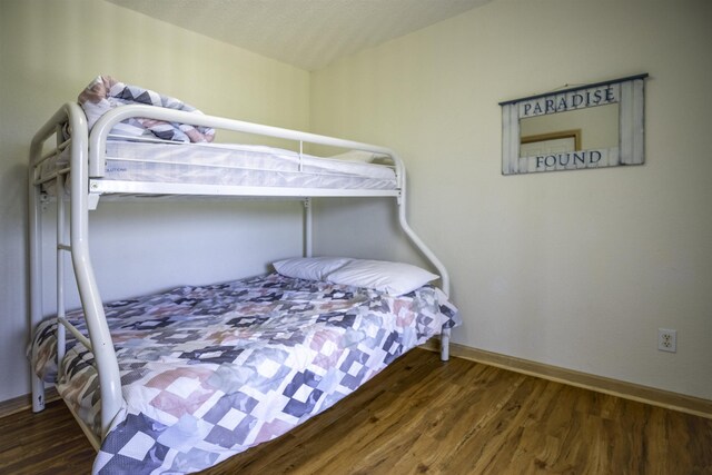 bedroom with dark wood finished floors and baseboards