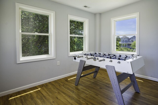 rec room featuring a wealth of natural light, dark wood-style flooring, visible vents, and baseboards