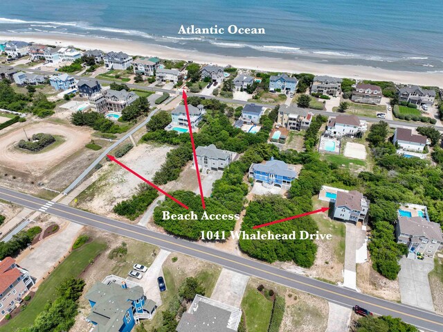 birds eye view of property featuring a water view, a residential view, and a view of the beach