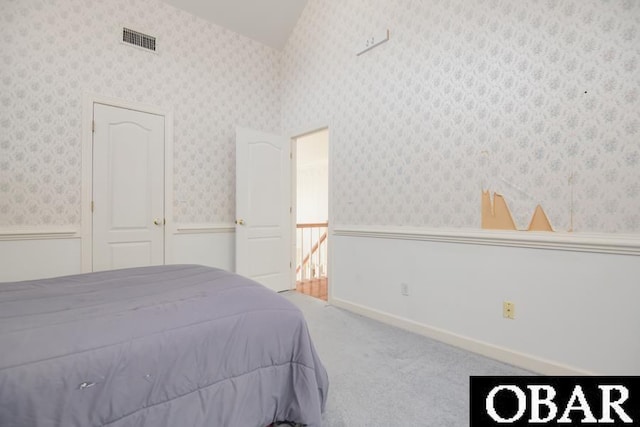 bedroom with wainscoting, carpet flooring, visible vents, and wallpapered walls