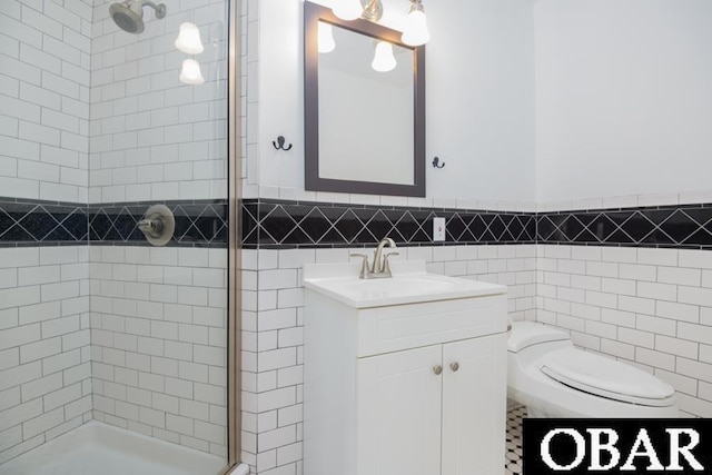 bathroom featuring tiled shower, toilet, tile walls, and vanity