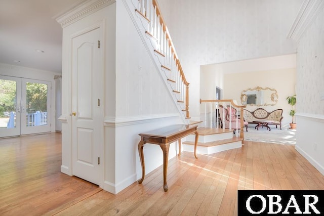 hall with light wood-style floors, baseboards, stairway, and french doors