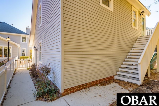 view of home's exterior with fence and stairway