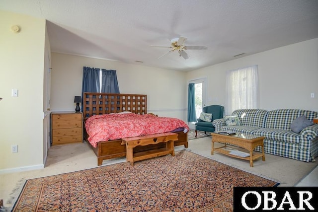 bedroom featuring light carpet, a textured ceiling, a ceiling fan, and baseboards