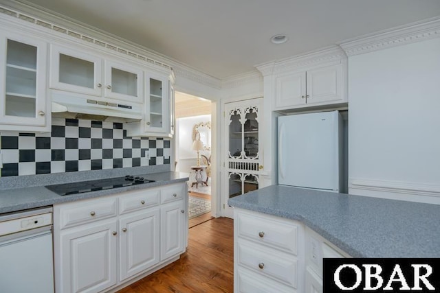 kitchen with glass insert cabinets, white appliances, white cabinets, and under cabinet range hood