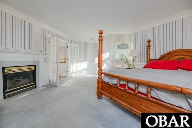 carpeted bedroom featuring wallpapered walls, ornamental molding, and a glass covered fireplace