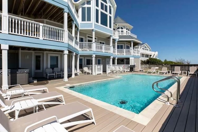 community pool with a patio area and a hot tub