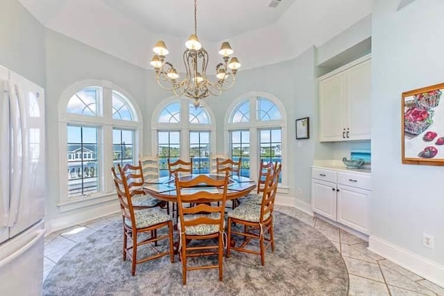 dining space featuring an inviting chandelier, light tile patterned flooring, a healthy amount of sunlight, and baseboards