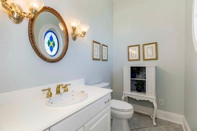 bathroom with toilet, an inviting chandelier, tile patterned flooring, baseboards, and vanity