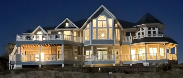 back of house at night with a balcony