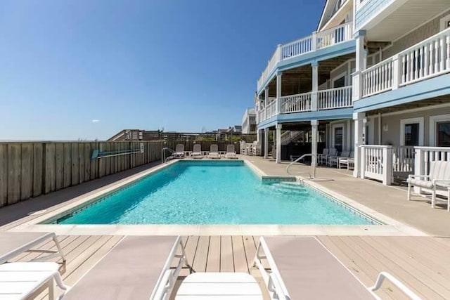 community pool featuring fence and a patio area