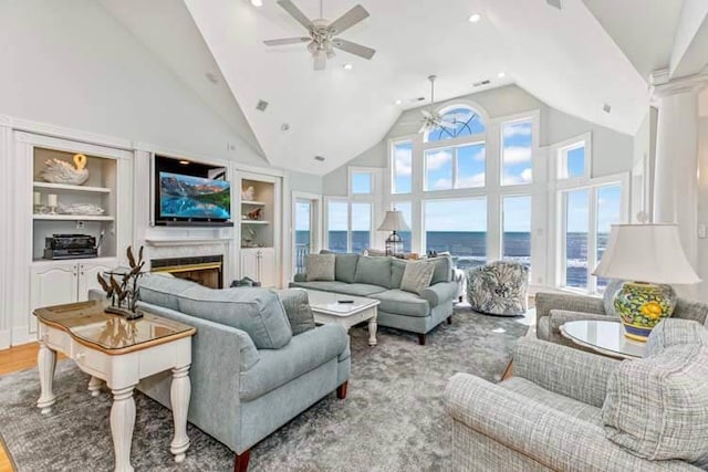 living room featuring ceiling fan, high vaulted ceiling, wood finished floors, and a fireplace