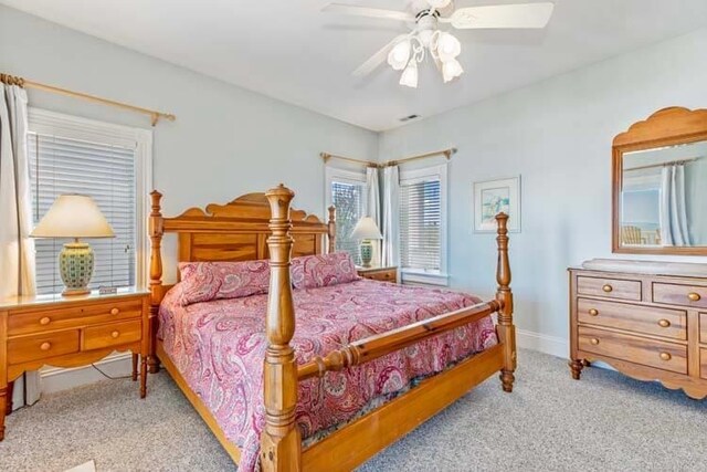 bedroom with light colored carpet, baseboards, and ceiling fan