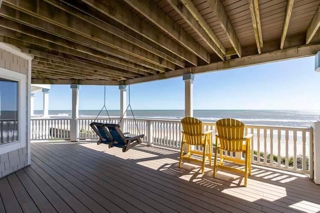 deck with a water view and a view of the beach