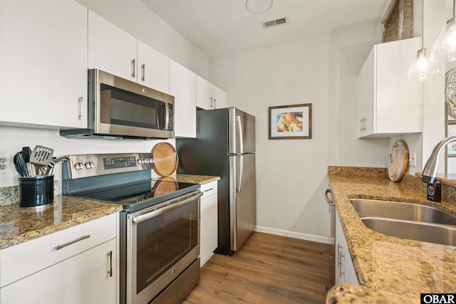 1113 Pirates Way Unit 1113, Manteo, NC 27954 - kitchen with stainless steel appliances, a sink, wood finished floors, baseboards, and white cabinetry